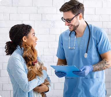 A Toronto veterinarian explaining test results to a pet owner holding her small dog